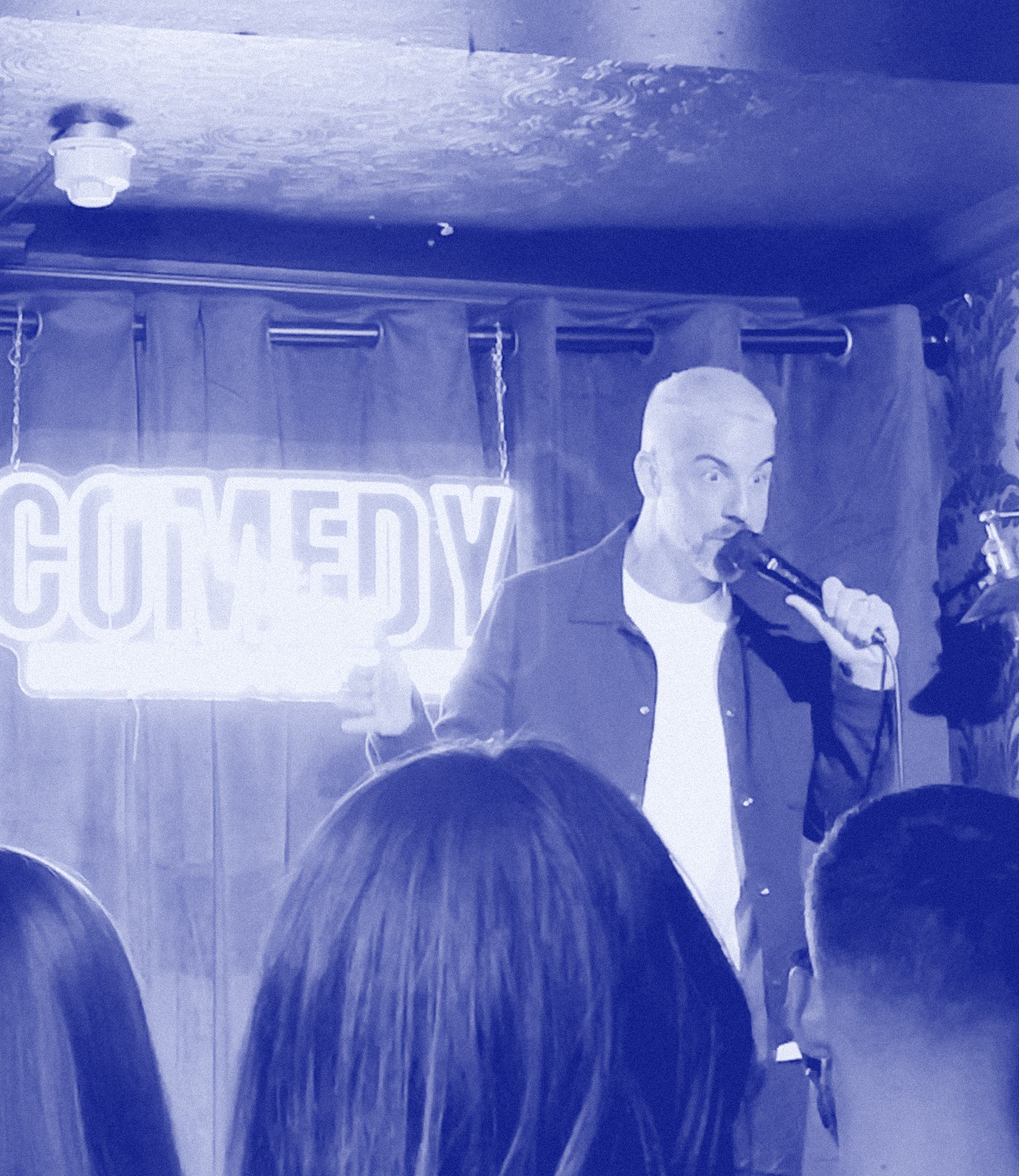 David William Bryan on stage at the Comedy Cellar